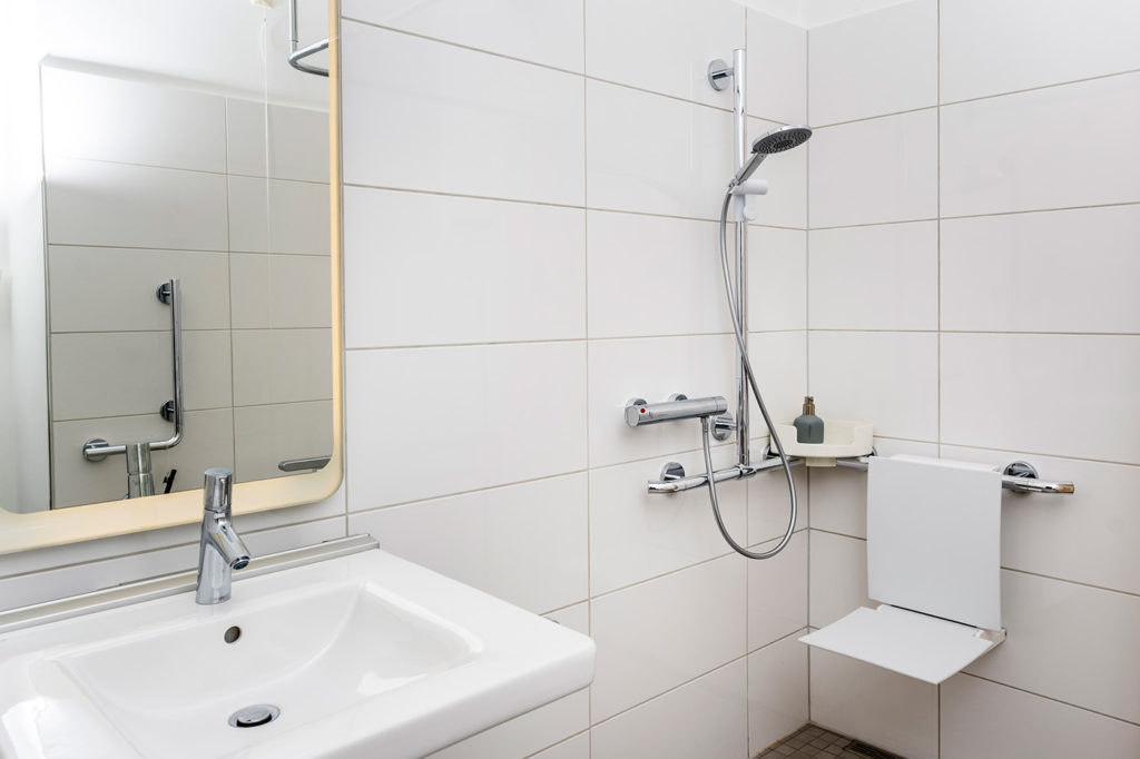 Barrierefreies Badezimmer: Bodengleiche Dusche mit Duschsitz und unterfahrbarem Waschbecken