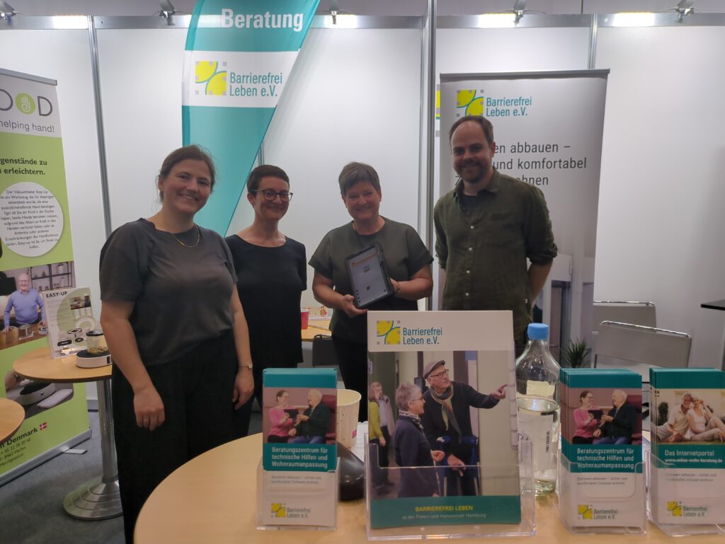 Isabelle Barthelmeß, Carolina Bergedieck, Simon Breul und eine Kollegin von barrierefrei Leben e.V. stehen am Messestand.