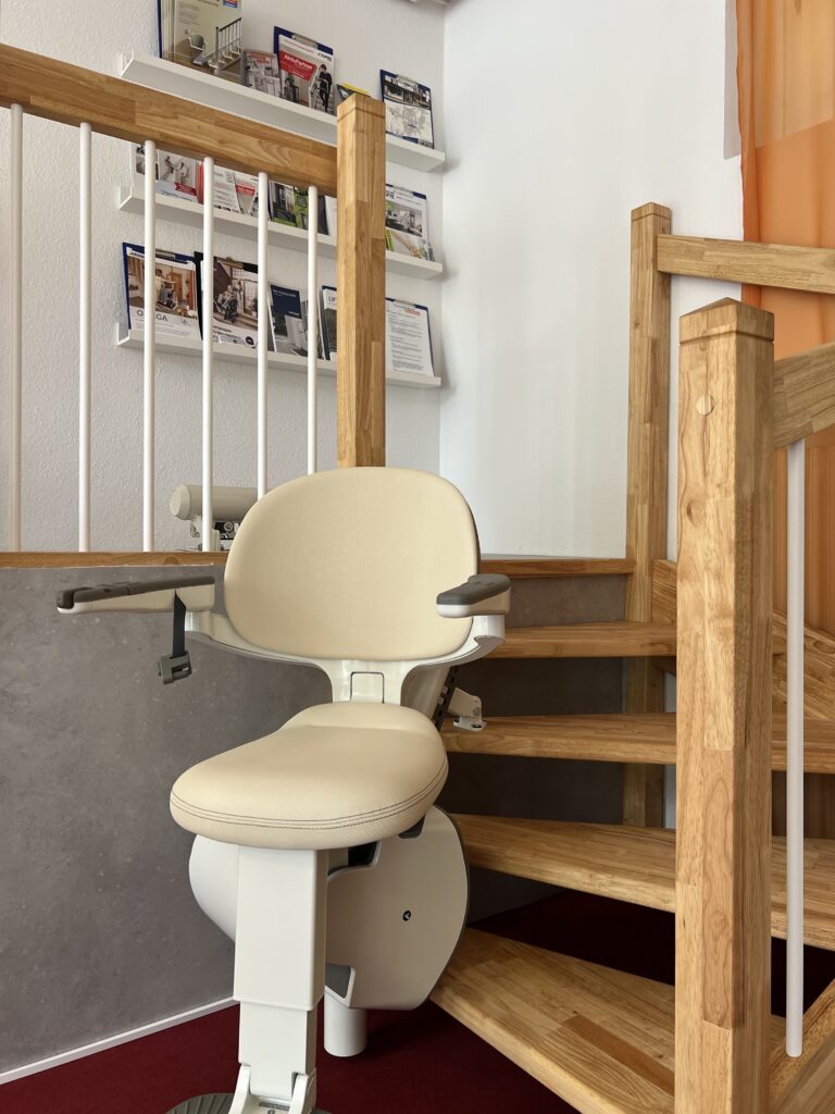 Ein Treppenlift auf einer kurvigen Treppe in der Ausstellung von KomFort.