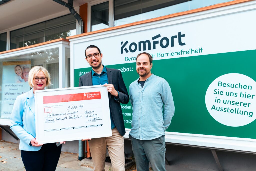 Engagement für barrierefreies Wohnen (v. l. n. r.): Susanne Beck von Sparkasse Immobilien Bremen überreicht einen symbolischen Spendenscheck über 1.200 Euro an Fördervereinsvorsitzenden Felix Schauppner und KomFort-Leiter Simon Breul.